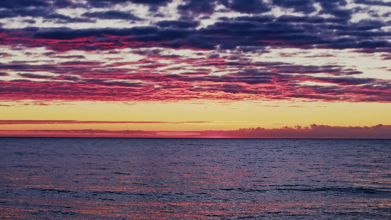 Drone captures colorful clouds, Baltic Sea at sunset, peaceful natural seascape