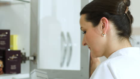 cosmetician tomando un cosmético del gabinete