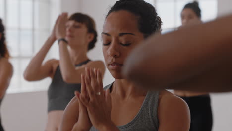 Gesunde-Yoga-Frau-Mit-Gemischter-Abstammung-Praktiziert-Gebetspose-Meditation-Mit-Einer-Gruppe-Gemischtrassiger-Frauen,-Die-Den-Fitness-Lebensstil-Genießen-Und-Im-Trainingsstudio-Einen-Flexiblen-Körper-Trainieren