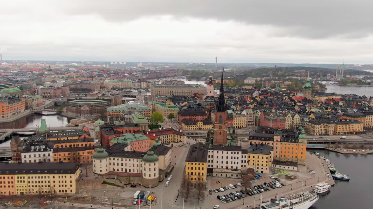 Soft orbiting aerial over central Stockholm, early spring day with very cloudy skies, highlighting iconic landmarks and cityscape