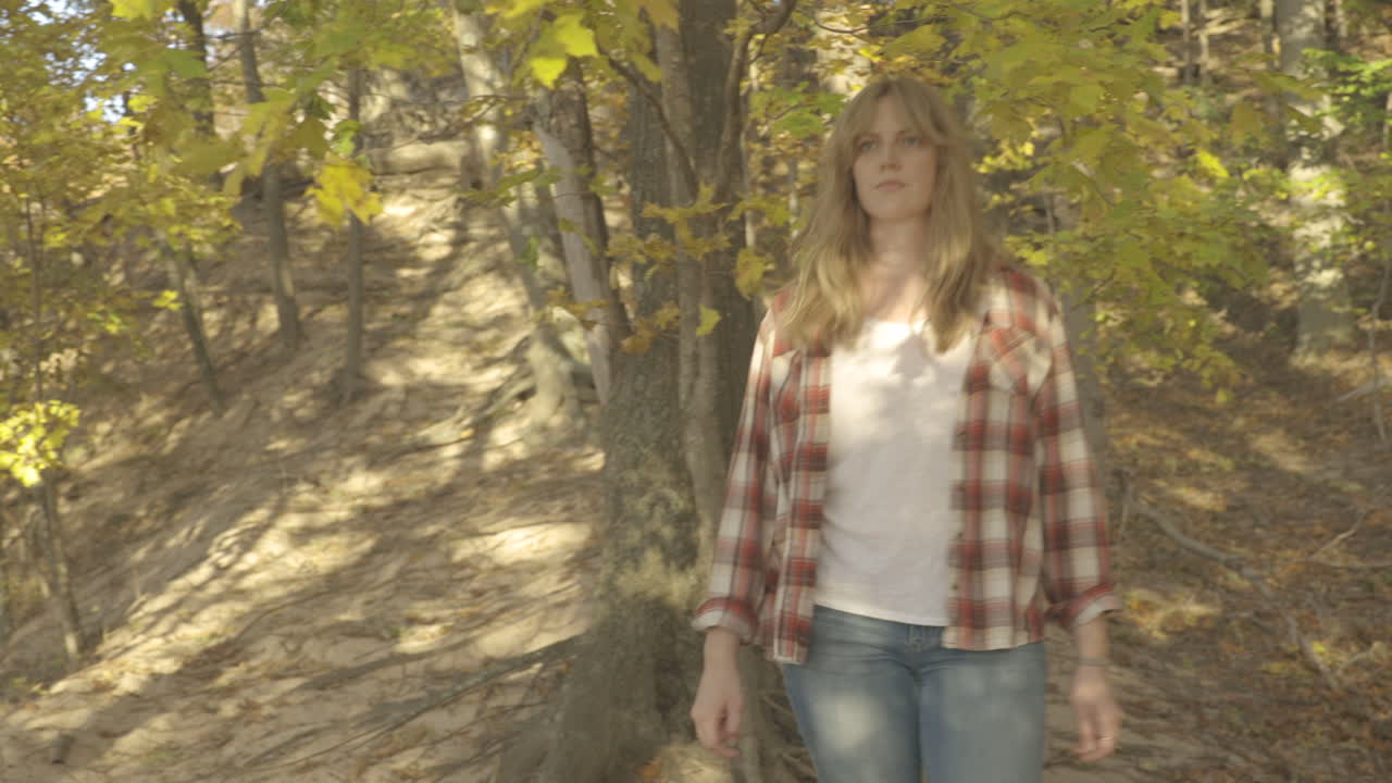 Young woman walking and looking through trees.  Shot in 4K