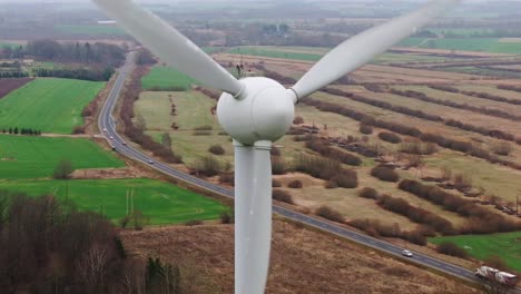 turbina eólica girando cerca de la autopista a9 en grobiņa, coches y un camión en movimiento