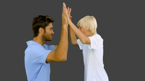 Mann-Gibt-Seinem-Sohn-High-Five-Auf-Grauem-Hintergrund