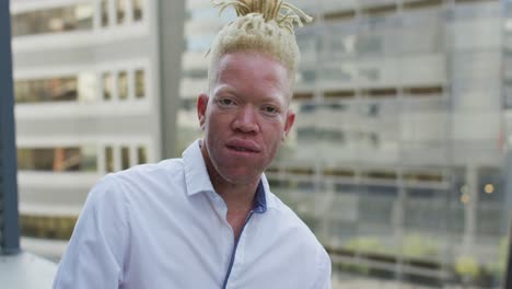 retrato de un feliz hombre de negocios albino afroamericano en la oficina creativa