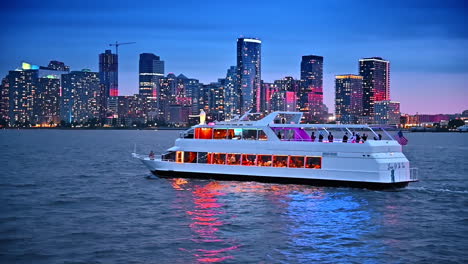 modern riverboat carrying tourists travels by the east river in new york. dazzling skyline of metropolis at dusk at backdrop