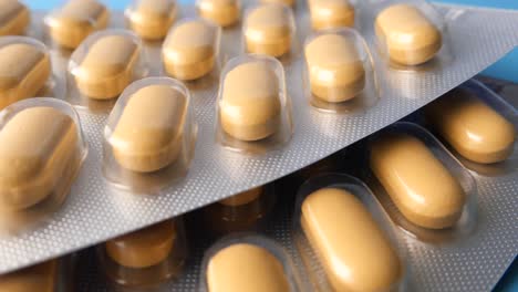 close-up of multiple blister packs of oval-shaped yellow pills