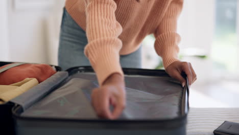 Hands,-woman-suitcase-and-packing-at-home