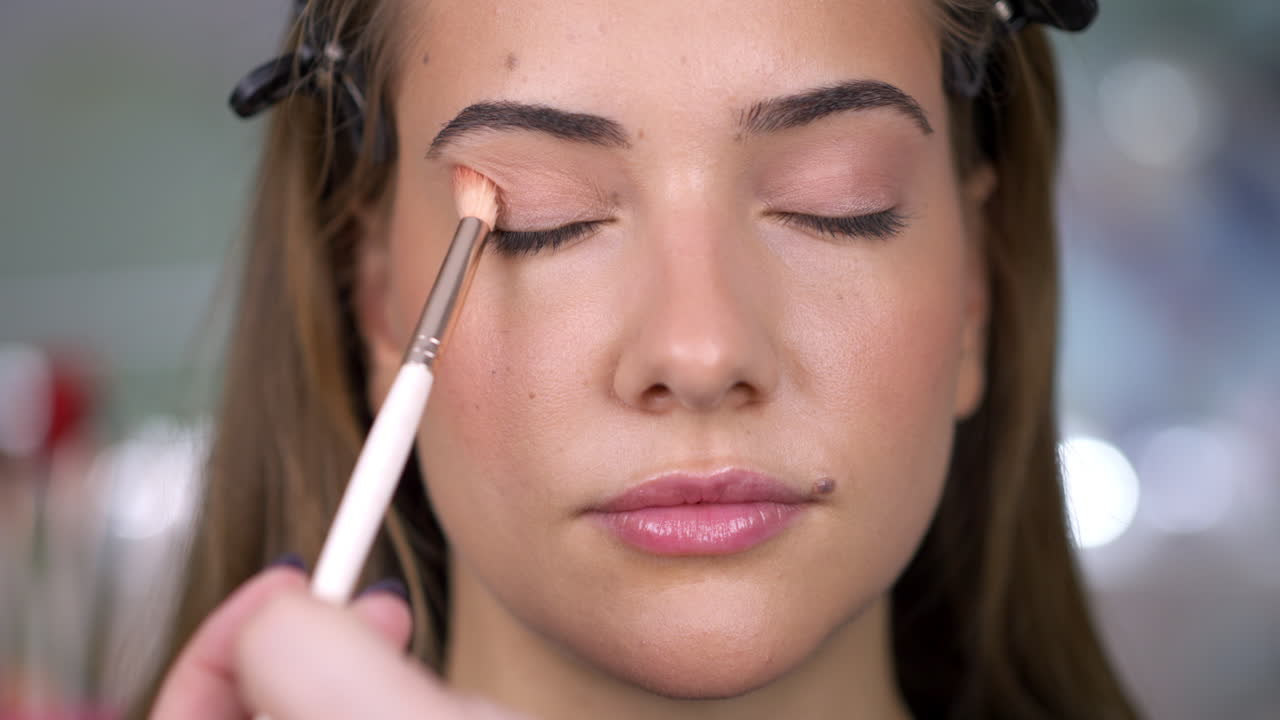 Woman getting eyeshadow applied during a makeup session