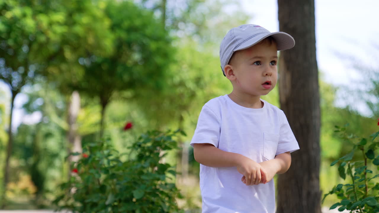 Anak kecil ceria bersenang-senang. Anak laki-laki kecil bermain di taman luar ruangan