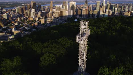 Vista-Aérea-Alrededor-Del-Monte-Royal-Cross-Con-El-Paisaje-Urbano-De-Montreal-En-Segundo-Plano