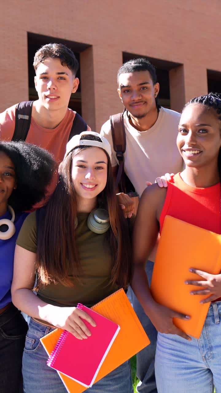 Gruppo eterogeneo di studenti universitari felici che posano nel campus.
