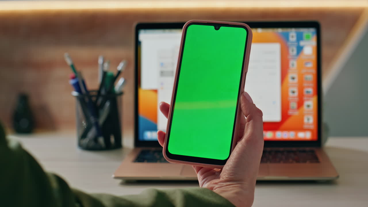 Unknown girl looking chroma key cellphone working at office with laptop close up