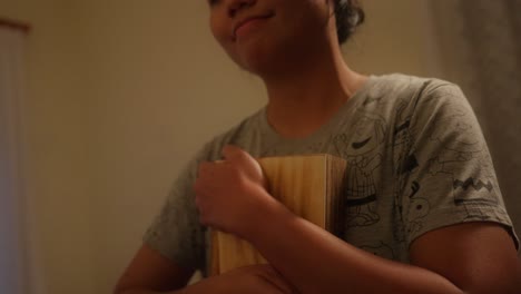 asian indonesian girl smile, hug wooden box while emotional, touched