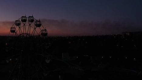silhouette of ferris wheel at night