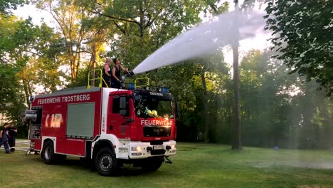 german firetruck spraying water for kids and trees on a hot summer day-3