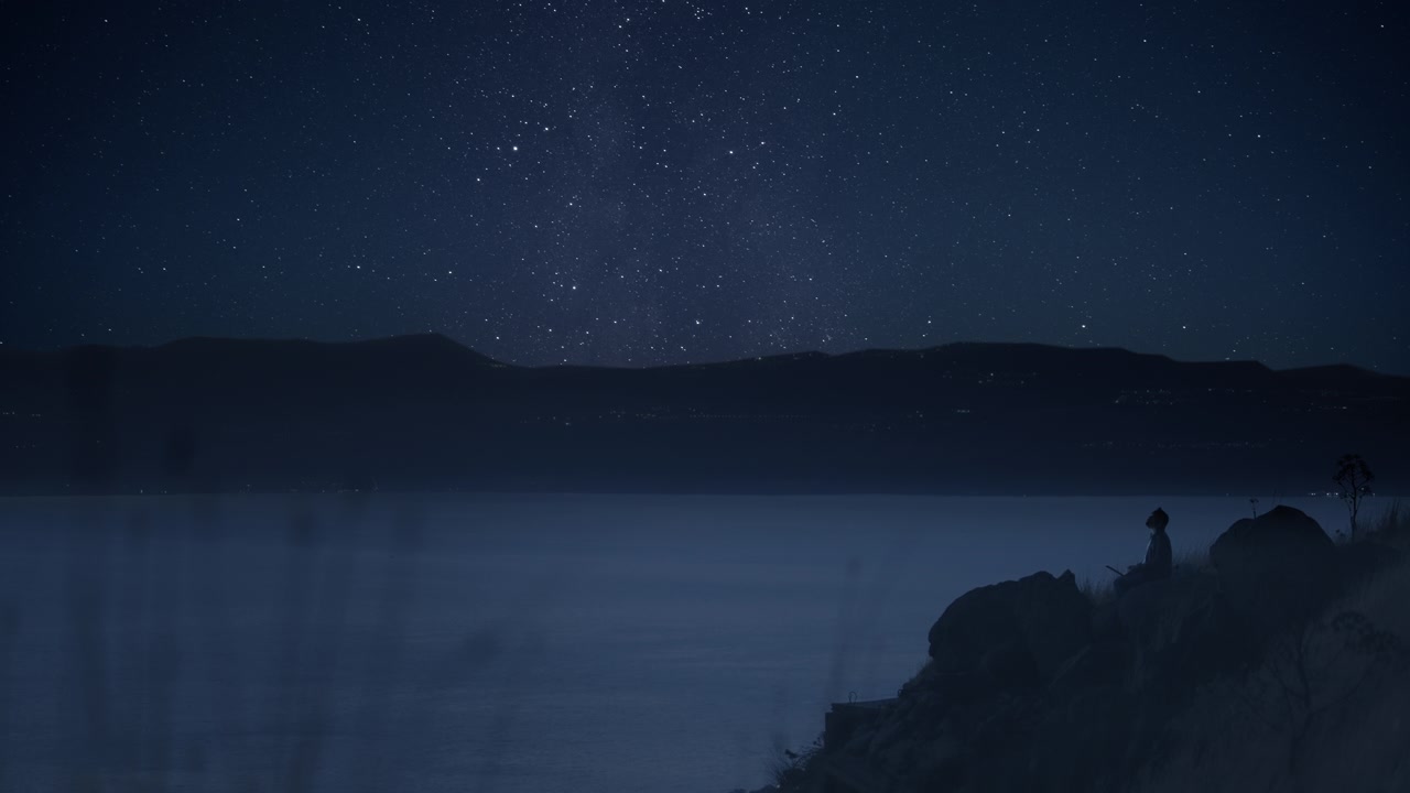 Un nomade digitale che lavora al laptop sotto il cielo notturno stellato