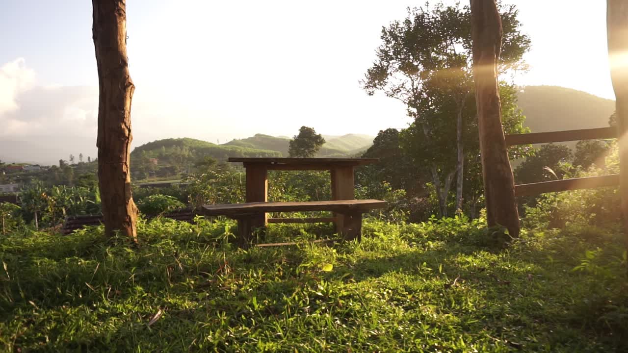 Table en bois au coucher du soleil, prise de vue du lointain au rapproché