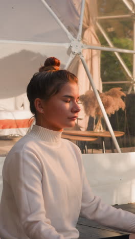 los jóvenes se sientan en la postura del loto en la tienda de glamping de cerca. la pareja enfocada termina el día con la práctica del yoga haciendo ejercicios de respiración. concepto de eco resort