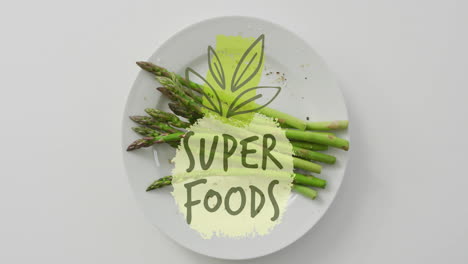 super foods text animation over plate of fresh asparagus