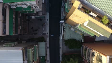 A-90-degree-Drone-shot-of-an-unrecognizable-man-walking-in-the-street-in-Taipei-by-sunset