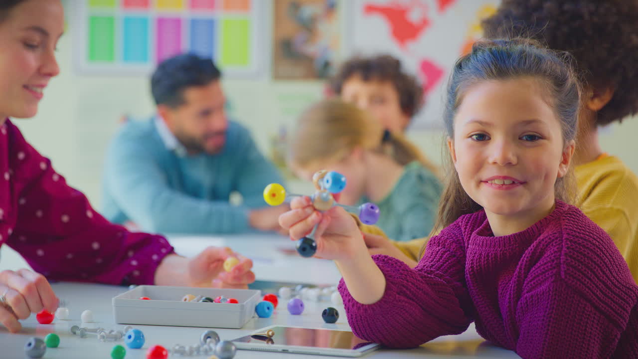 estudiante de primaria con profesores en el aula estudiando el modelo molecular en la clase de ciencias
