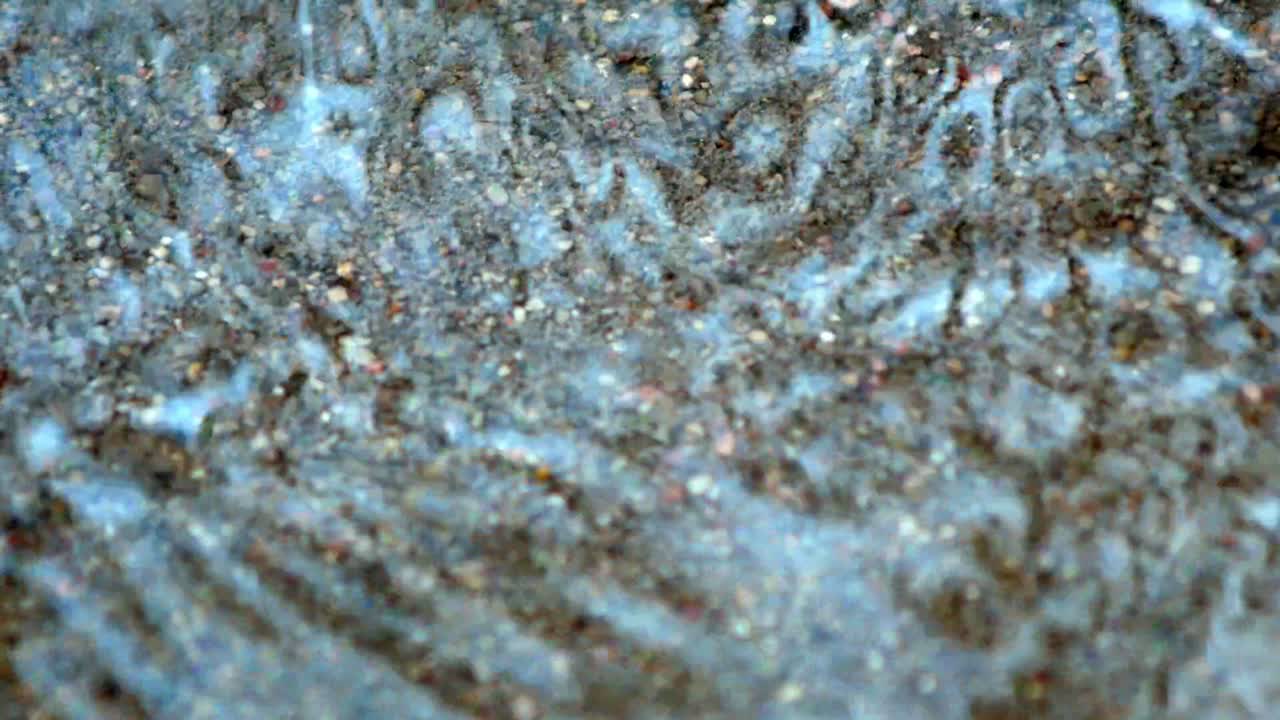 las gotas de lluvia caen al agua en la carretera de hormigón y se salpican