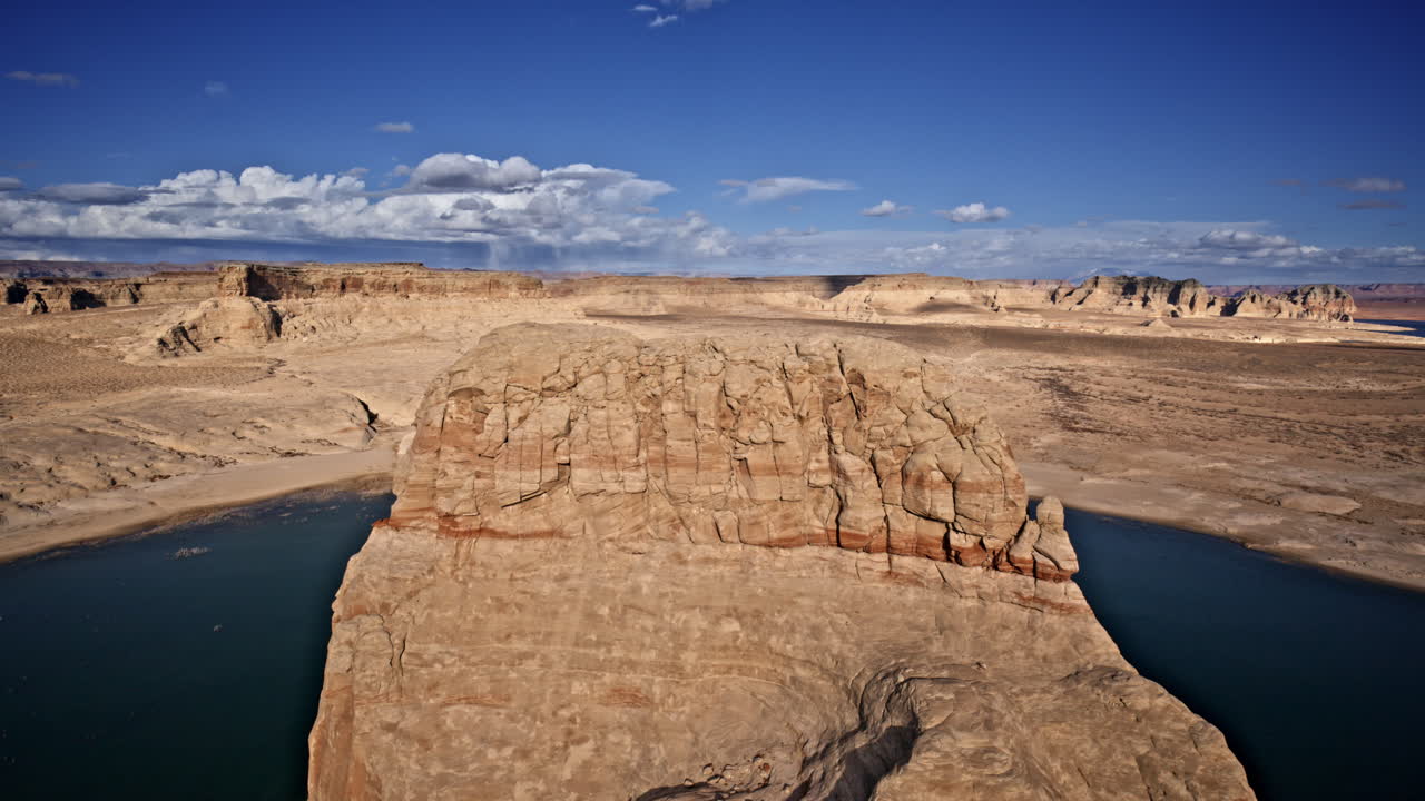 Overhead drone view capturing the grandeur of a lone rock rising from Lake Powell, surrounded by canyons near Page, Arizona.
