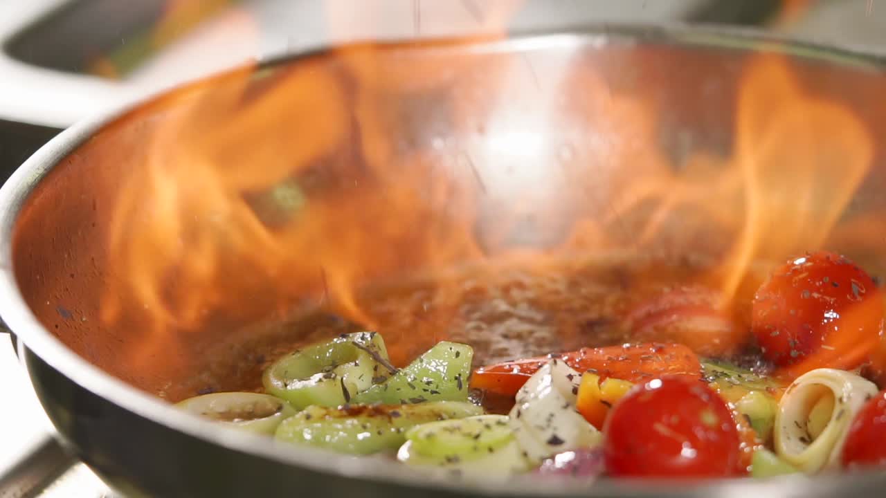 verduras cocinadas en una sartén con llama