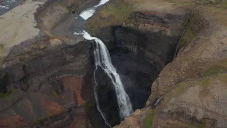 Vista-Aérea-De-La-Cascada-De-Haifoss-Chocando-Contra-Las-Rocas-En-Islandia.-Vista-Superior-Desde-Arriba-De-Haifoss,-La-Segunda-Cascada-Más-Alta-De-Islandia.-Cascada-En-El-Río-Fosa