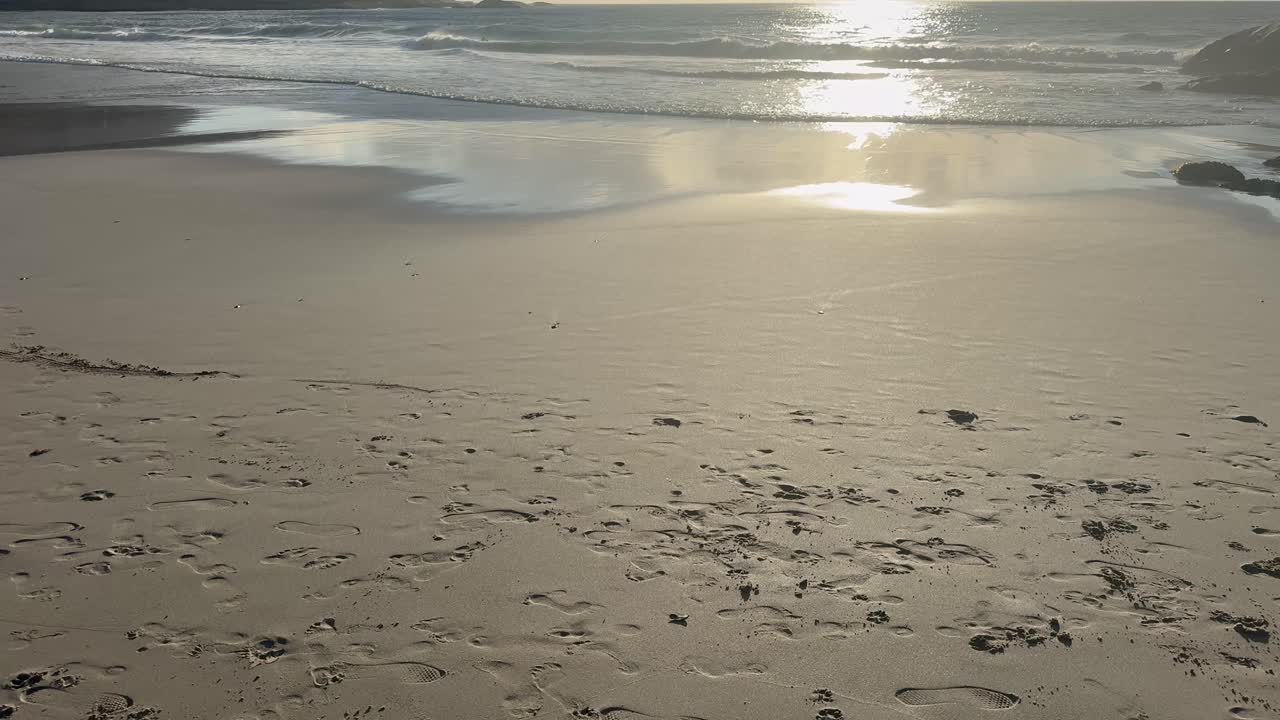 Solnedgang. Vandet spejler sig i strandkanten på en strand i Cape Town, Sydafrika
