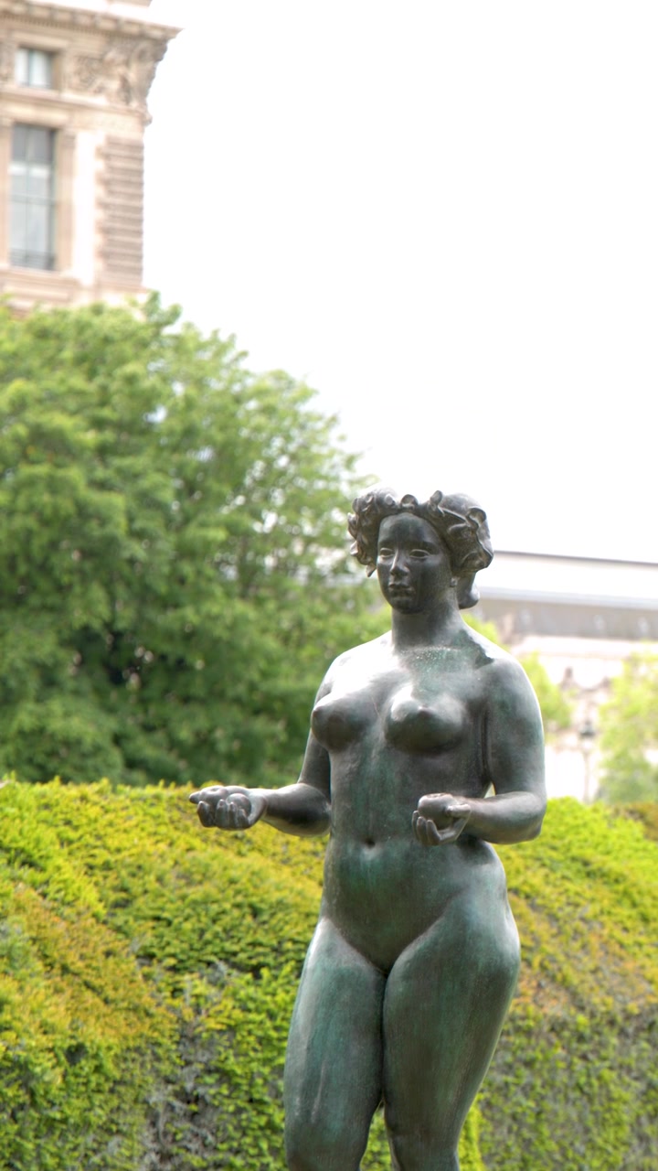 Inquadratura media di una scultura femminile in bronzo contro siepi verdi nel Giardino delle Tuileries, Parigi.