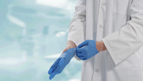 sección media de un médico masculino con guantes quirúrgicos contra un fondo blanco