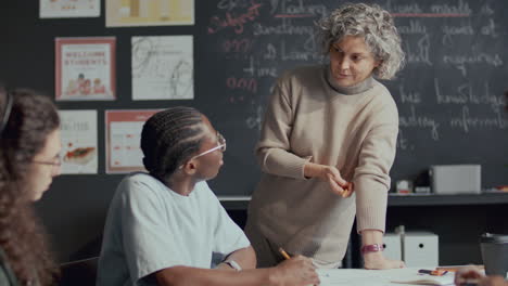 teacher explaining textbook material to student during english lesson