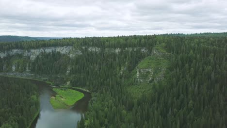 aerial view of a river winding through a lush forest and mountains