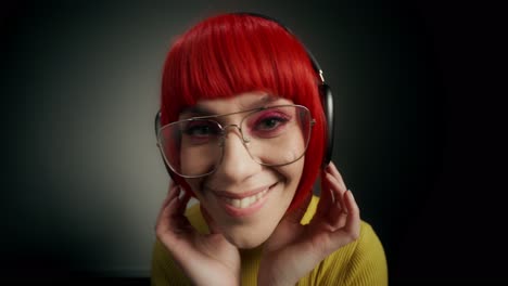 woman with red wig, headphones, and glasses