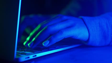 persona escribiendo en una computadora portátil por la noche