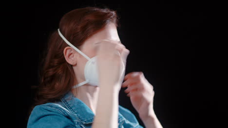 a young caucasian woman puts on her n95 mask