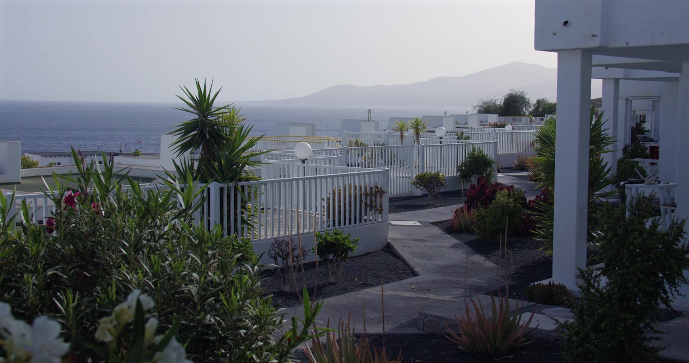 Ripresa grandangolare molto ampia con vista a ovest su edifici imbiancati a calce a Puerto del Carmen, Lanzarote, Isole Canarie.