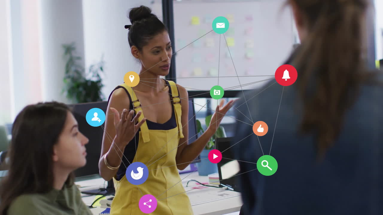 Social media icons animation over diverse team discussing in modern office