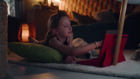 girl and dog relaxing with tablet at home