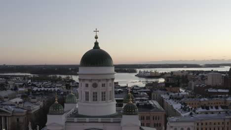 Aerial-view-drone-flying-close-to-the-dome-of-Helsinki-Cathedral-with-city-and-sea-in-background