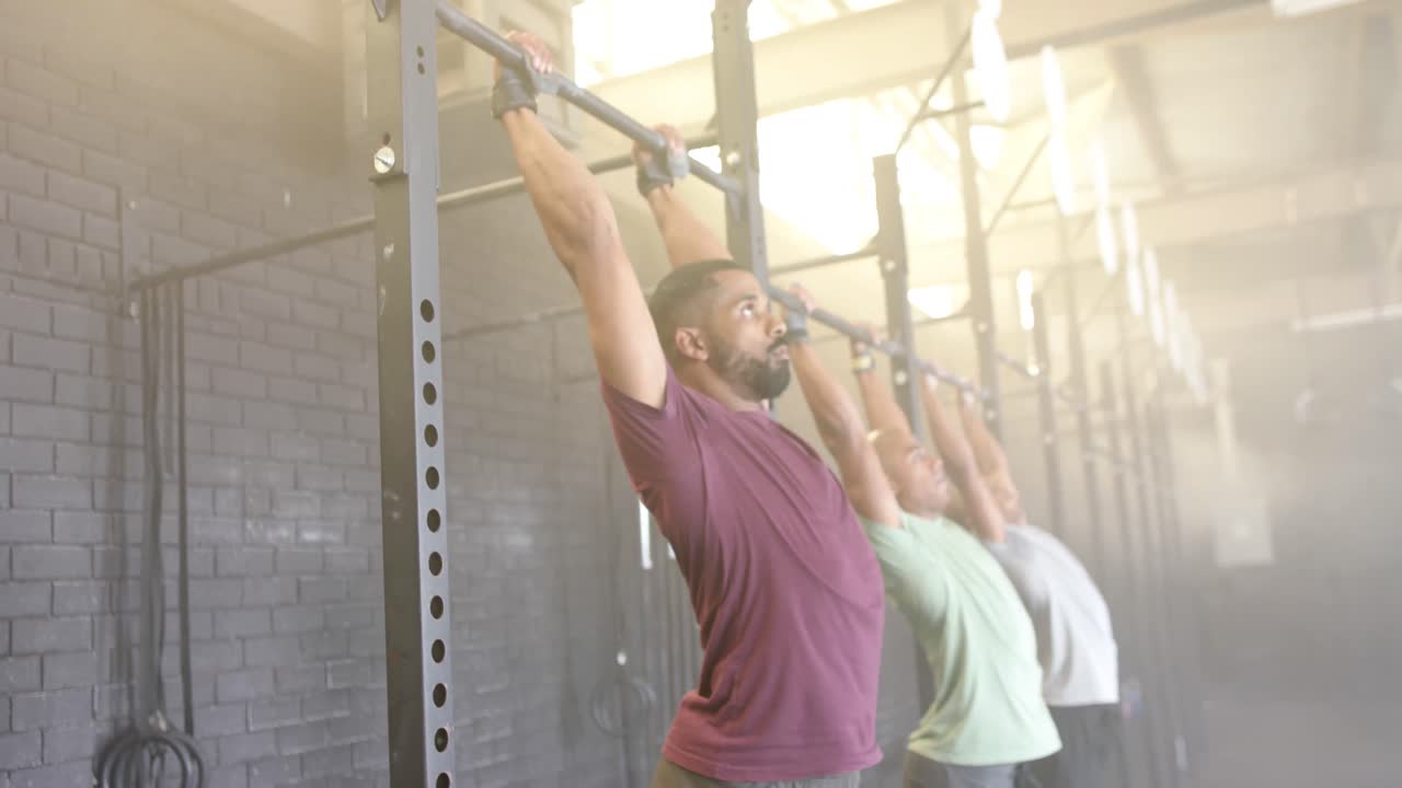 diversas clases de acondicionamiento físico de grupo masculino en el gimnasio haciendo flexiones en barras, en cámara lenta