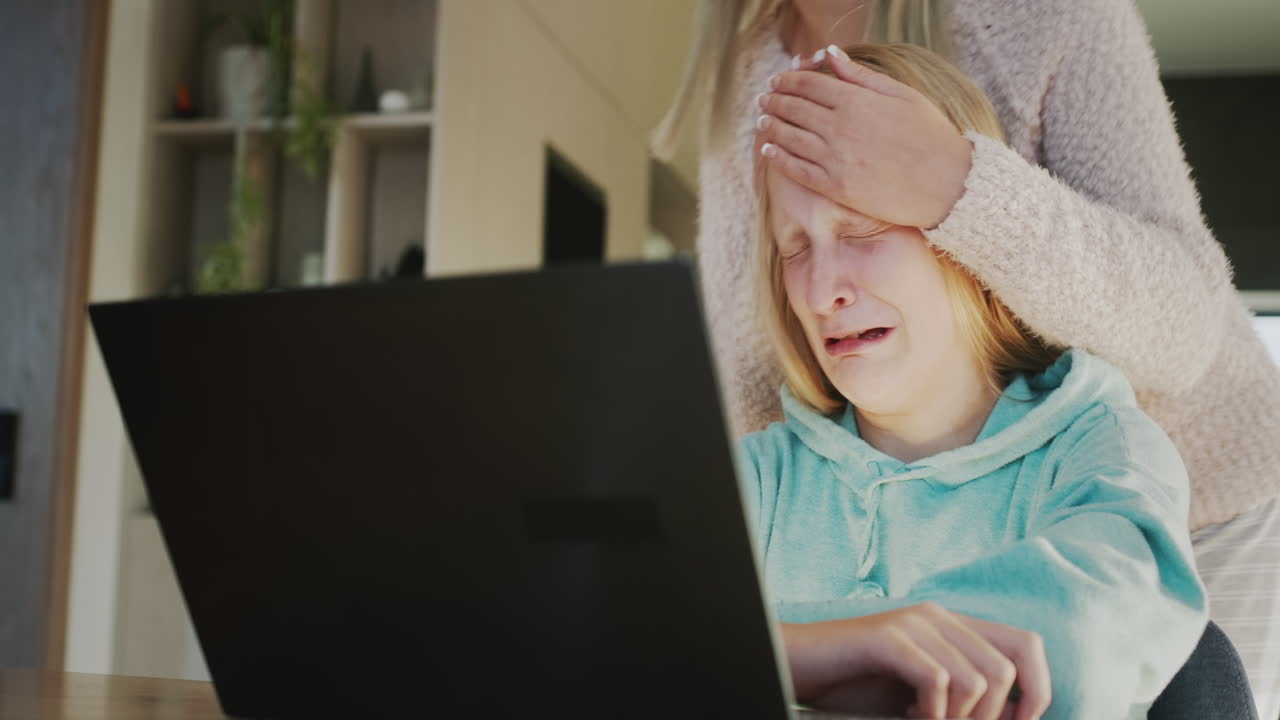 노트북 화면 에서 울고 있는 십대 소녀 를 진정 시키는 여자