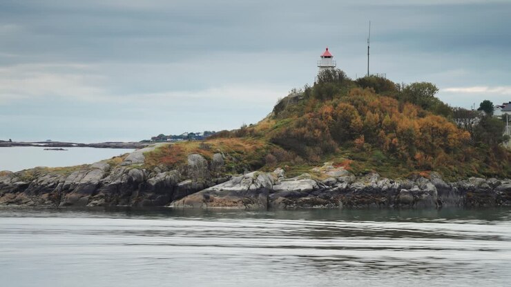 Un faro in miniatura su una piccola isola rocciosa coperta d'erba