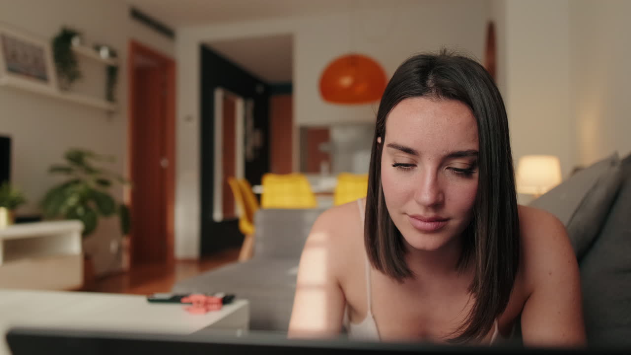 Cute young Woman Browsing on Laptop at Home