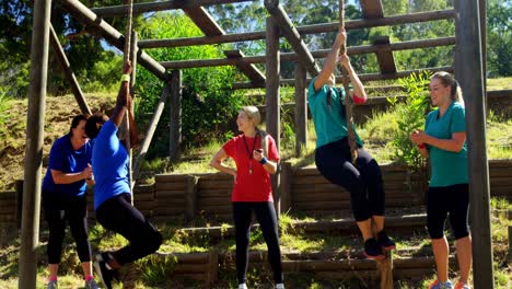 entrenadora que ayuda a las mujeres en la escalada de cuerdas