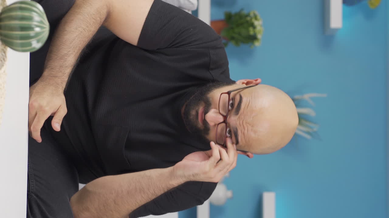 Vertical video of The man wearing glasses.