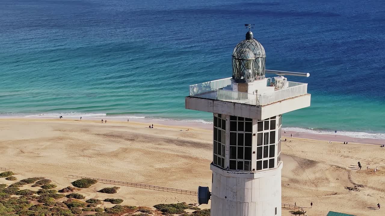 Il faro di Fuerteventura si erge imponente sopra la spiaggia sabbiosa e le onde oceaniche