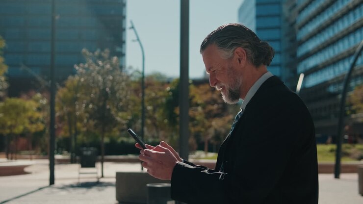 hombre de negocios usando el teléfono fuera del edificio de oficinas