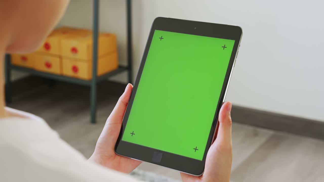 Close up of woman holding in hands a digital tablet with green screen for internet online, chroma key screen for advertising.
